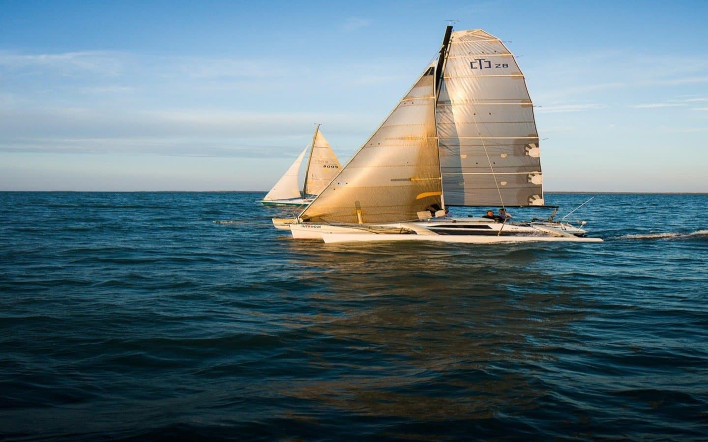 Sailing yachts under way at sunset on open water