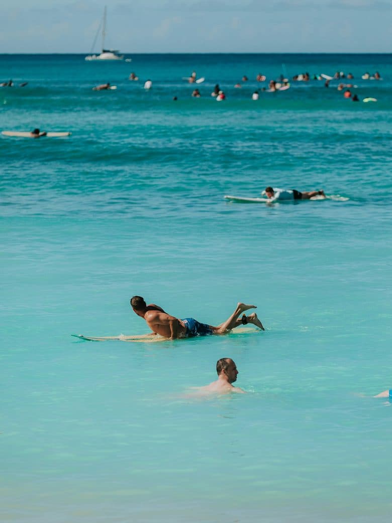 Surfers waiting on turquoise water off the beach