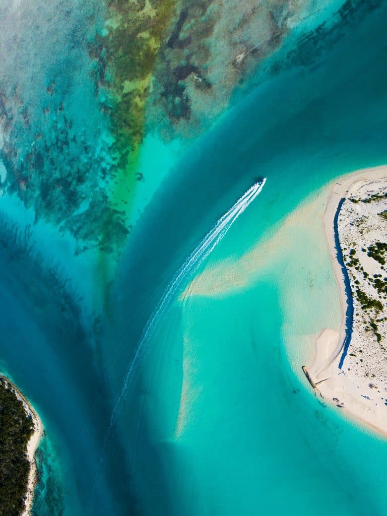 Aerial view of a tender crossing a turquoise channel