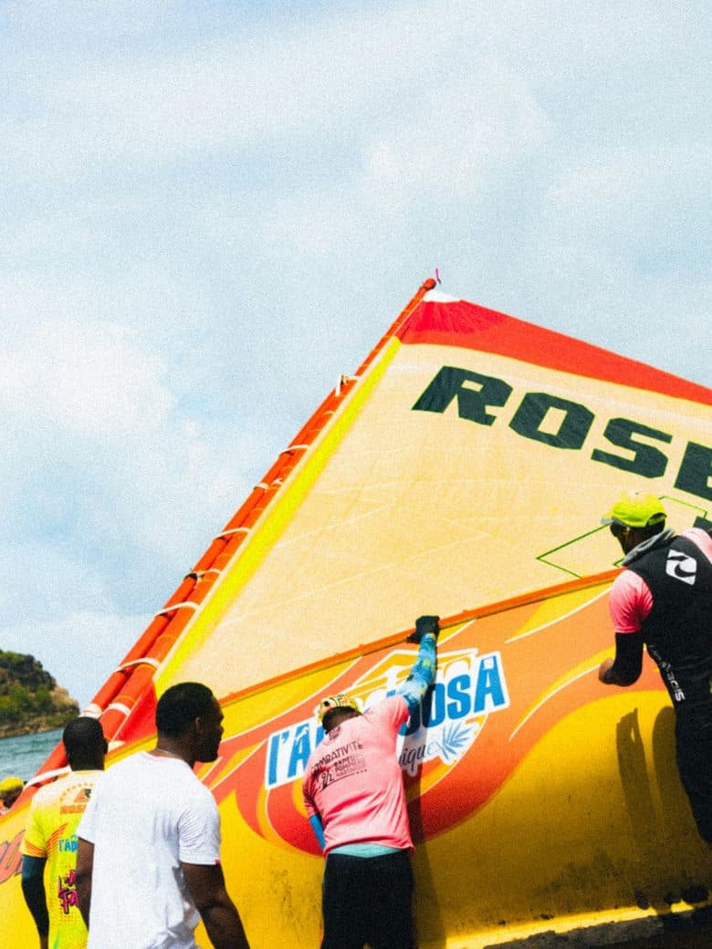 Crew raising the sail of a traditional Caribbean yole