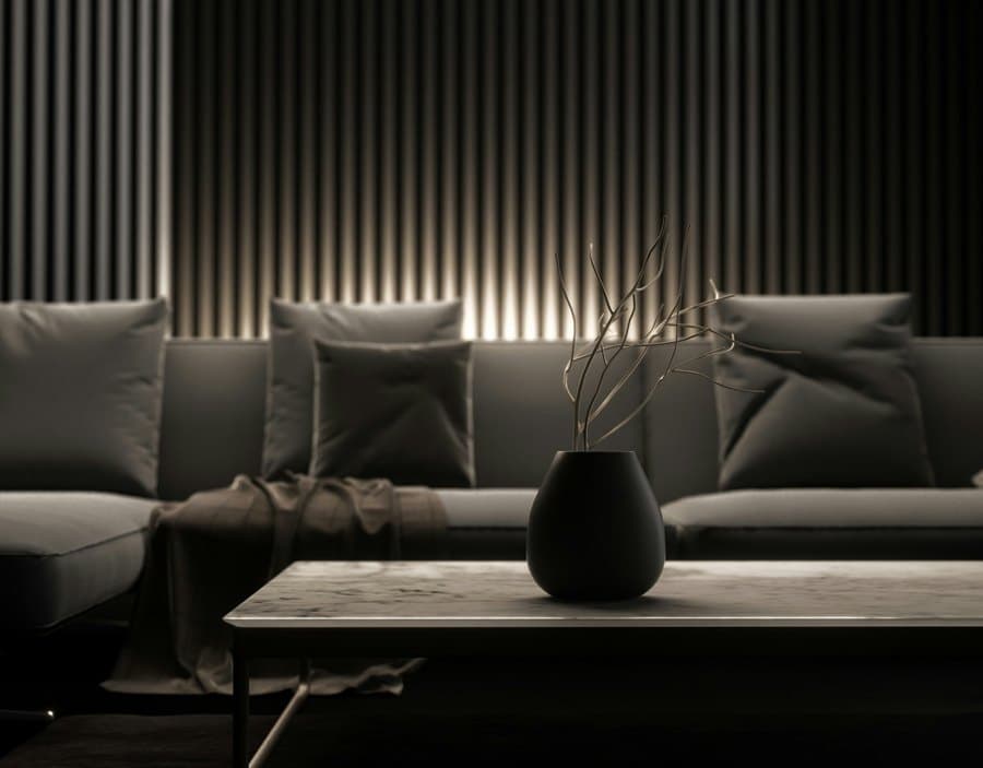 Dark living room with a grey sofa, cushions and a marble coffee table